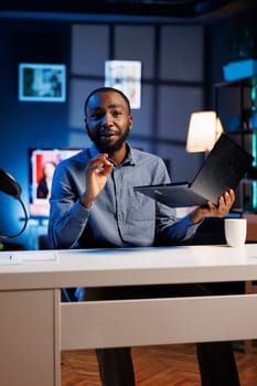 African american entertainer presenting laptop from brand sponsoring video, urging viewers to purchase it. Man does influencer marketing by advertising digital device to audience