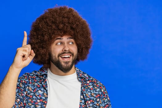 Eureka. Inspired Caucasian man pointing finger up with open mouth, having good idea, plan, startup, showing inspiration motivation gesture, problem solution. Happy guy isolated on blue background