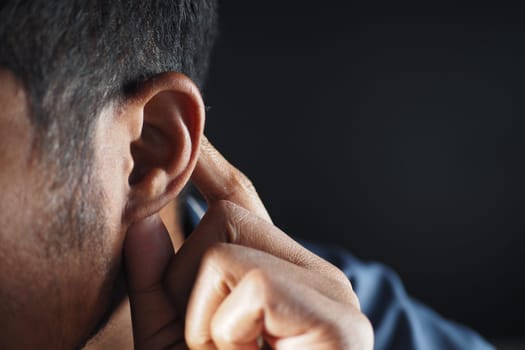 young man having ear pain touching his painful ear