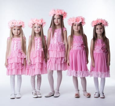 Full length portrait of five little girls in pink dresses and wreaths