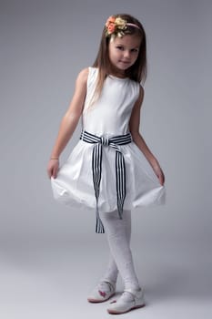 Full length portrait of little girl in white dress