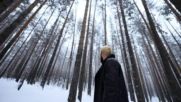 Caucasian man lost in winter forest. Media. Desperate young hipster man is cold with his red skin among trees and snow