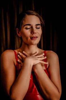 Young woman in red corset and black leather pants. Sexy brunette in red and black costume. Role play. Entertainment