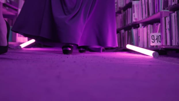 Women are mysteriously walking in library. Stock footage. Secret sorority in night library. Elegant women mysteriously gather in night library with flashing light.