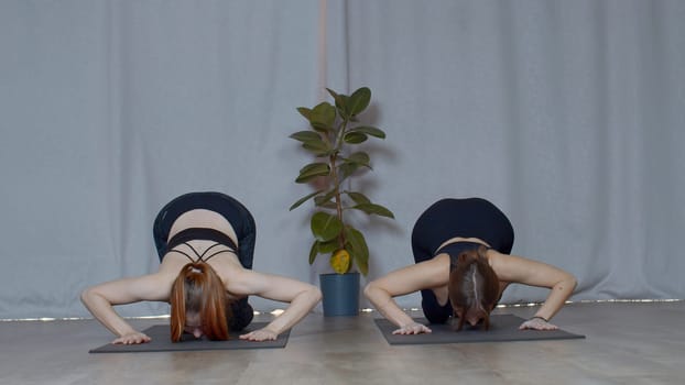 Athletic young women doing exercisizes for the spine stretching. Media. Concept of inner peace and no stress