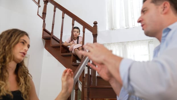 Stressed and unhappy young girl watch her parent arguing from the stair. Domestic violence at home and traumatic childhood develop to depression and anxiety. Unhealthy family concept. Synchronos