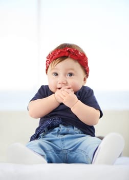 Portrait, sitting and bed for baby fashion in family home, cute and trendy street style on curious girl toddler. Creative, child development and growth, adorable headband accessory with funky clothes.