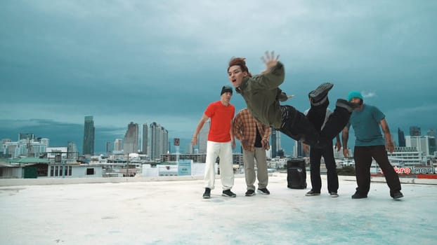 Hispanic hipster dancing surrounded by multicultural friend at city view with blue sky. Group of street dancer performing at rooftop. Active, fun, happy atmosphere. Outdoor sport 2024. Endeavor.