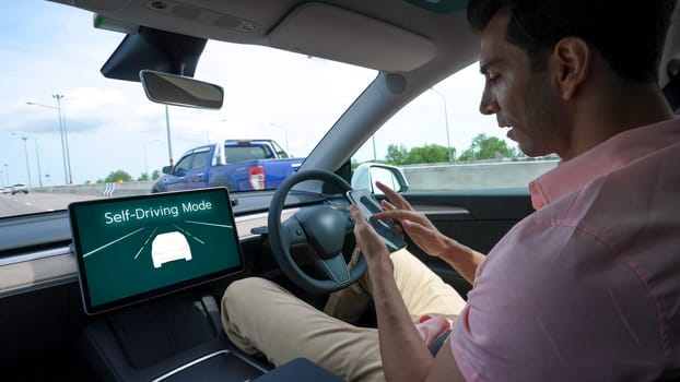 Self driving car or autonomous vehicle travel on speed highway with driverless system and autopilot mode allowing man driver relax and focus on smartphone without compromising safety. Perpetual