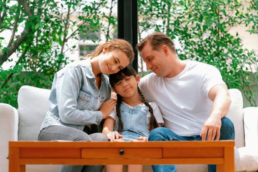 Parents comforting their daughter with loving hug, helping her feel secure and protected from fear, rest her head on shoulder. Happy family love and child care support concept. Synchronos