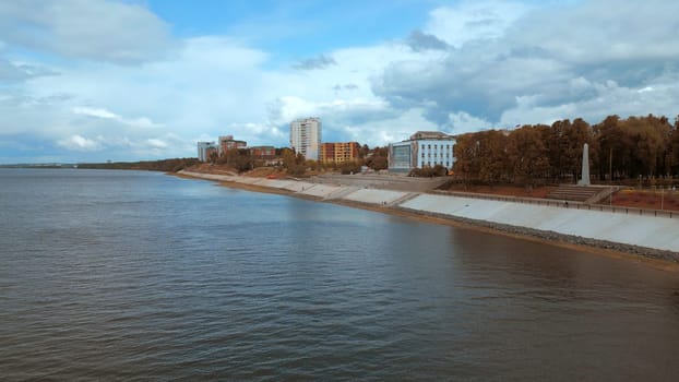 Top view of river embankment of city with forest. Clip. Landscaped embankment of city river bank. Beautiful landscape of river embankment with city park.