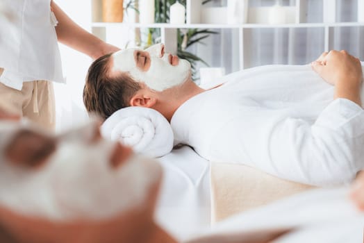 Serene ambiance of spa salon, couple indulges in rejuvenating with luxurious face cream massage with modern daylight. Facial skin treatment and beauty care concept. Quiescent