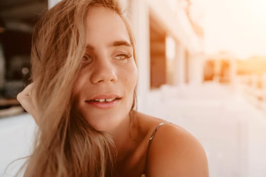 Happy woman portrait in cafe. Boho chic fashion style. Outdoor photo of young happy woman with long hair, sunny weather outdoors sitting in modern cafe