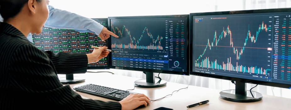 A cropped close-up image of professional smart trader hand pointing at financial growth graph while write data analysis in notebook. Business finance and Stock market investment concept. Burgeoning.