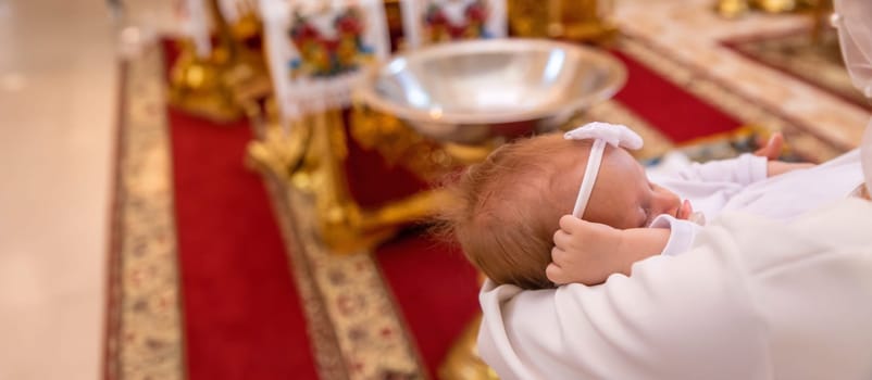 a woman holds a child in a church. baptism of a child. church