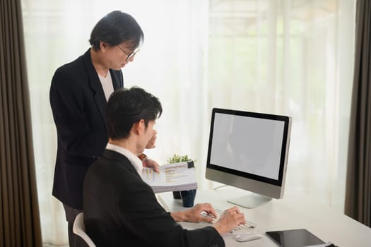 Middle age businessman planning new strategy with young colleagues at office.