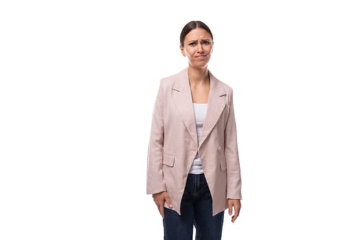 young business woman with a ponytail hairstyle dressed in a beige jacket is having doubts on a white background.