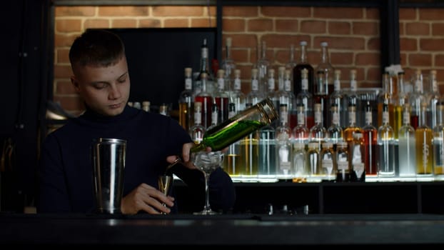 Handsome barman preparing cocktail drinks. Media. Concept of night life at bar, club, restaurant
