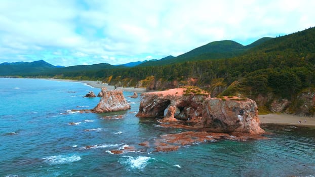 Top view of amazing cliffs of sea coast. Clip. Rocks with erosion of sea waves create amazing stone arches. Beautiful rocky arches on seashore.