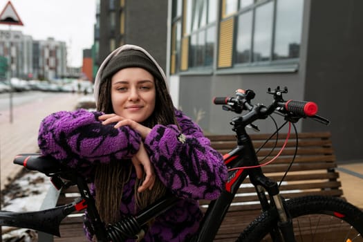 Bicycle rental concept. A young woman with dreadlocks spent a walk around the city riding a bicycle.