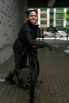 Sports concept, young woman walking on a day off while riding a bike.