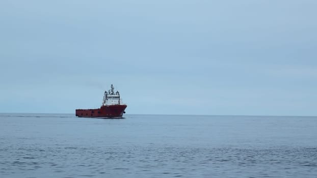 Floating ferry on background of cloudy sea horizon. Clip. Beautiful landscape with ferry in open sea. Ship on cruise in ocean in calm cloudy weather.