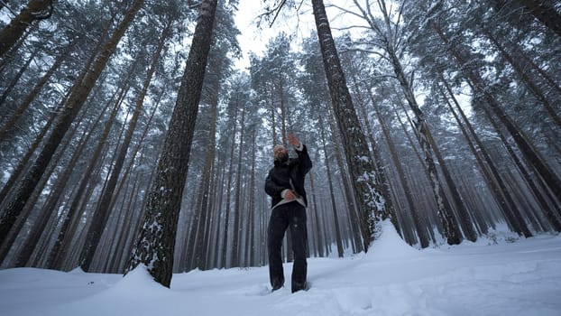 Shooting clip in winter forest. Media. Stylish man is rapping in winter forest. Man moves stylishly and raps in winter forest. Music video.