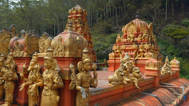 Hindu temple with golden statues. Action. Red temple with golden Buddhist statues. Temple of Hindu origin in Sri Lanka.