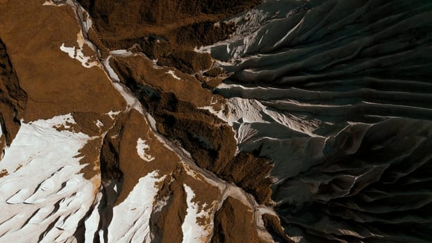 Aerial top view of the mysterious mountain rocks. Clip. White stone layers and brown ground