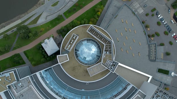 Top view of modern round building with dome. Stock footage. Beautiful architecture of business center with round structure and dome. Rings of building with beautiful facade.