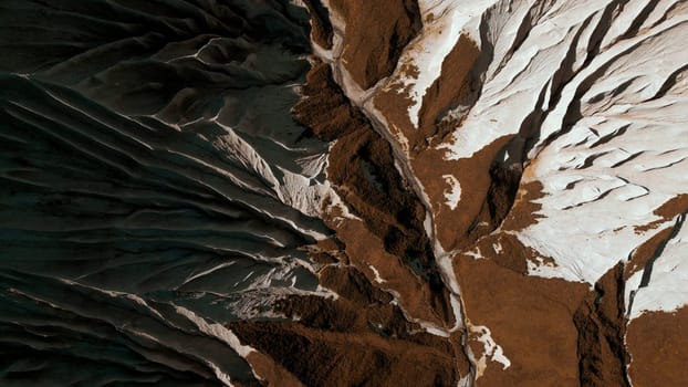 Aerial top view of the mysterious mountain rocks. Clip. White stone layers and brown ground