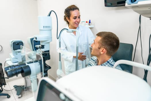 Female optometrist talking with male patient in the clinic