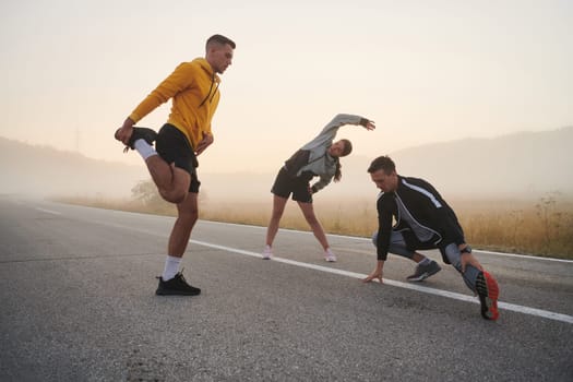 A vibrant and diverse group of athletes engage in stretching and warming up exercises, showcasing their unity and readiness for an invigorating morning run.