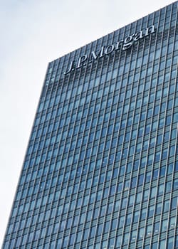 London, United Kingdom - February 03, 2019: Sun shines on J P Morgan signage at top of their UK branch at Canary Wharf. JPMorgan Chase is US multinational investment bank founded (originally) 1799