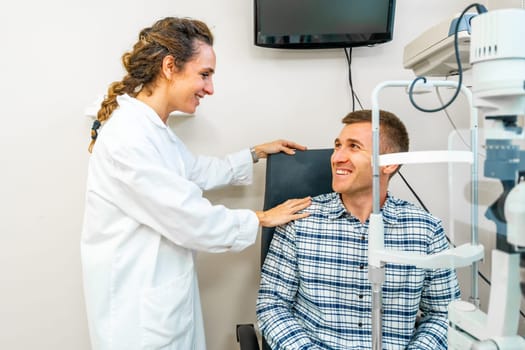 Friendly female optometrist comforting a patient during a check up in the clinic