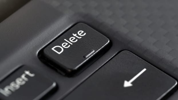 Closeup macro detail of Delete key on black laptop keyboard