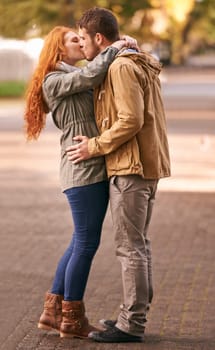 Couple, love and kiss with affection at park or outdoor in cold weather, together and support in new York. Relationship, date and bonding for romance with desire, care and happiness with commitment.