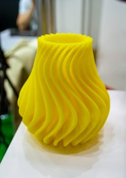 Abstract art object printed on 3D printer. Colored yellow creative model printed on 3D printer from molten ABS PLA plastic filament. Object printed FDM printer. Additive progressive modern technology