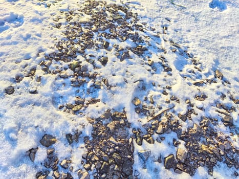 Texture of small stones with snow. Background of pebbles and ice. Abstract background, texture, pattern, frame, place for text and copy space