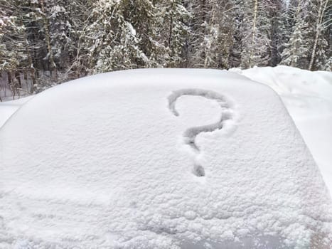 Question mark written in the snow on car. The cold frosty texture of the snow and the question mark. Background, place for text, copy space