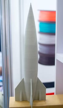 Abstract art object printed on 3D printer. Colored beige creative model rocket printed on 3D printer from molten ABS, PLA plastic filament. Object printed FDM printer. Additive new modern technology