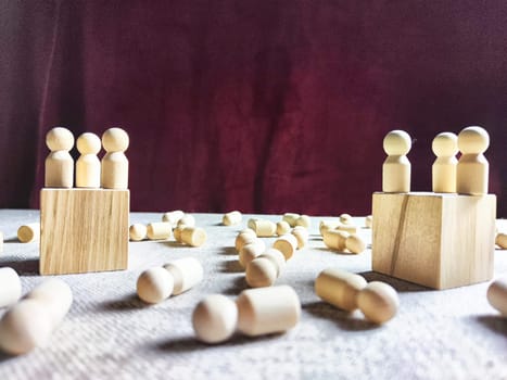 Wooden toys stand opposite and lot of lying figures. Concept of dispute between leaders of two groups. Government and deaths of citizens and soldiers. War in Russia, Ukraine, Israel, Palestine