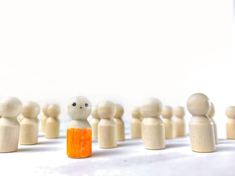 Wooden figurines with a leader and group with partial focus. The concept of distinguishing a leader from the crowd. Sighted, intelligent, different among the blind group