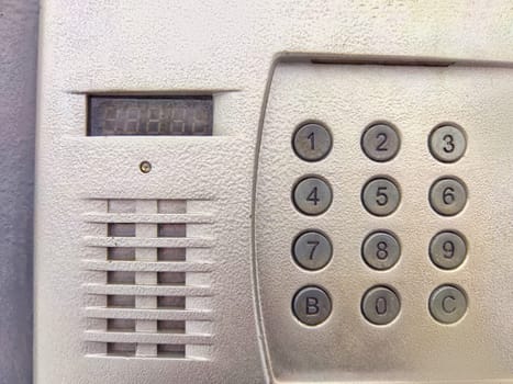 A detailed look at a wall intercom with a keypad for secure access