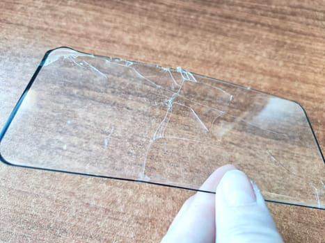 Removing Protective Film From Cracked Screen. Peeling off a cracked screen protector from a phone