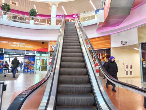 Arkhangelsk, Russia - February 28, 2024: Escalator in Modern Shopping Mall. Big Escalator inside a vibrant shopping center