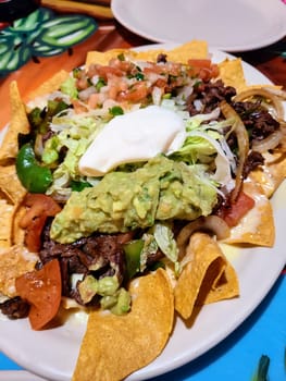 Vibrant Mexican nacho feast with guacamole centerpoint, enjoyed in a Fort Wayne, Indiana restaurant