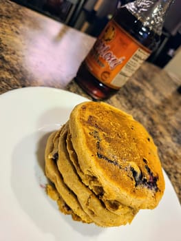 Inviting breakfast scene featuring homemade blueberry pancakes in a cozy Fort Wayne kitchen, enhanced by syrup and indoor lighting.
