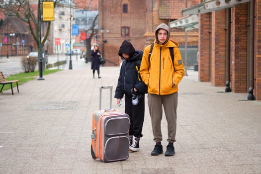 A teenage boy and a teenage girl next to a suitcase. The concept of tourism
