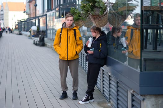 A teenage boy and a teenage girl walk through unfamiliar tourist spots